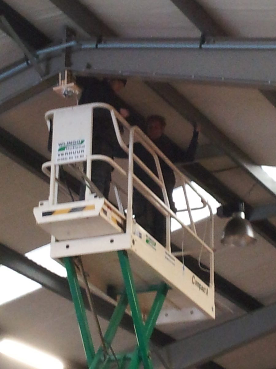 Monteur op hoogwerker plaatst camera