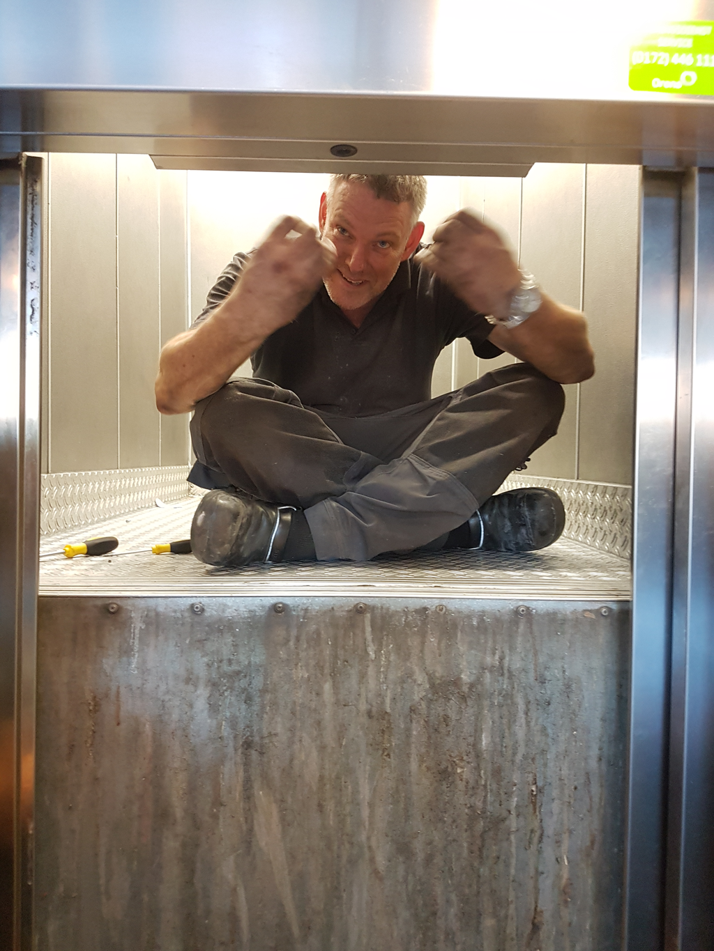 Monteur bovenop de liftcabine